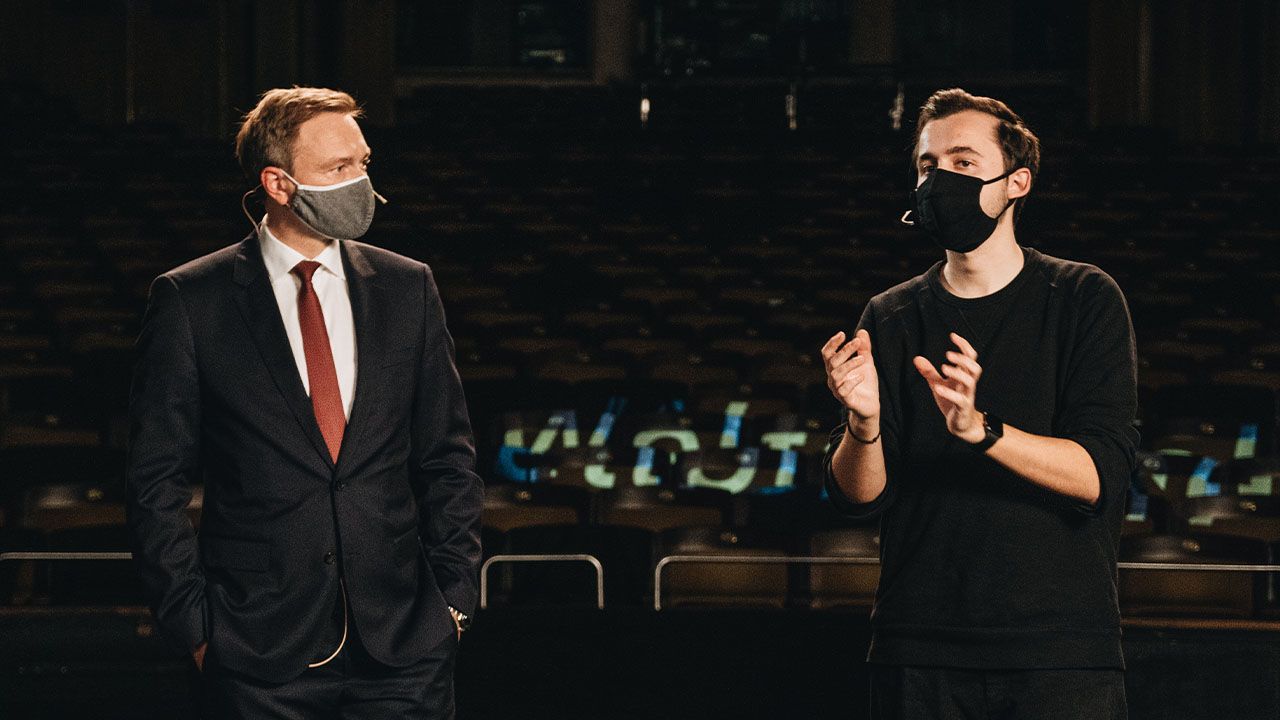 Ein Regisseur von Visionary Berlin im Gespräch mit Christian Lindner am Set des Dreikönigstreffen-Livestreams, um die perfekte Umsetzung der Botschaft und des Auftritts sicherzustellen.