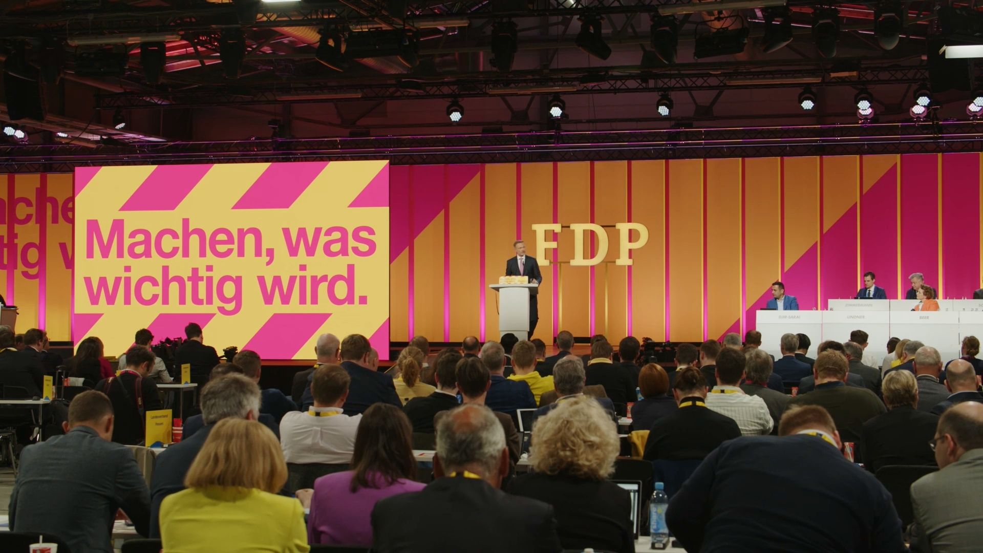 A wide shot of the main stage at the FDP Federal Party Conference 2023 during a keynote speech, showing the impressive stage design with the slogan "Machen, was wichtig wird."