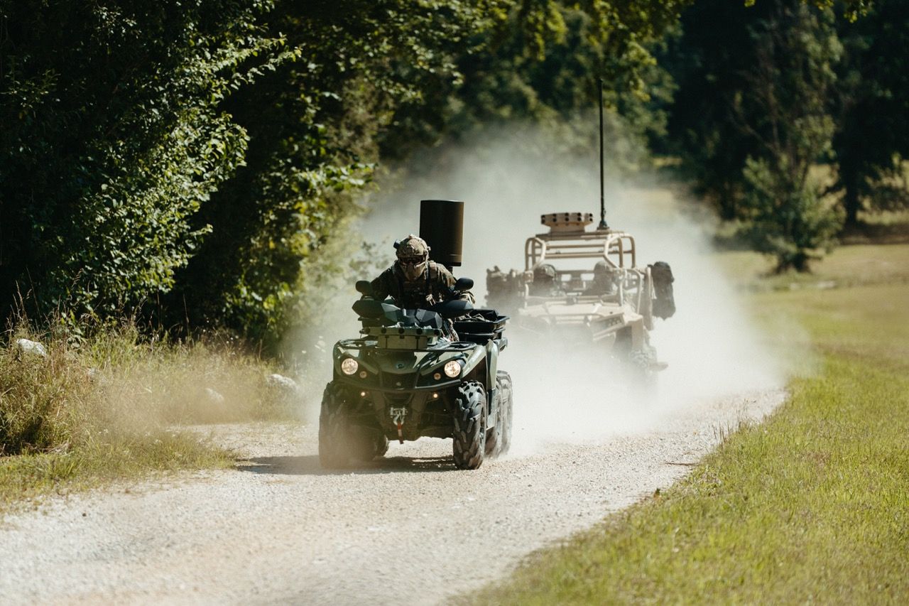 A dynamic action shot from the Saab L20C launch film, featuring soldiers on ATVs moving at speed, demonstrating the high-mobility scenarios for which the product is designed.