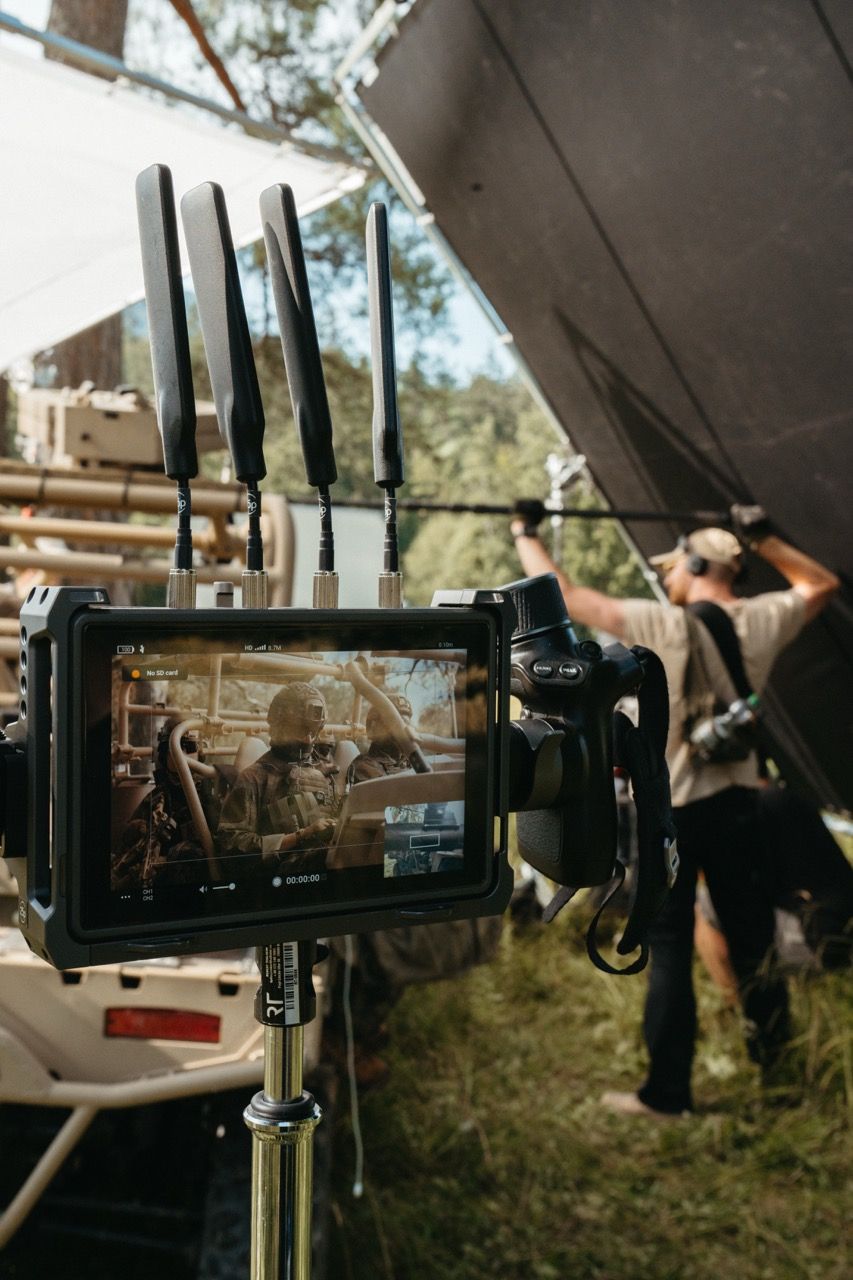 A close-up of a monitor showing the live camera feed, as the Visionary Berlin team frames a shot of soldiers in a tactical vehicle for the Saab L20C project.