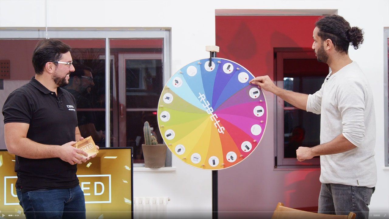 An interactive segment from the 'Huawei Rebels' broadcast, where hosts use a colorful prize wheel to drive audience engagement and excitement.