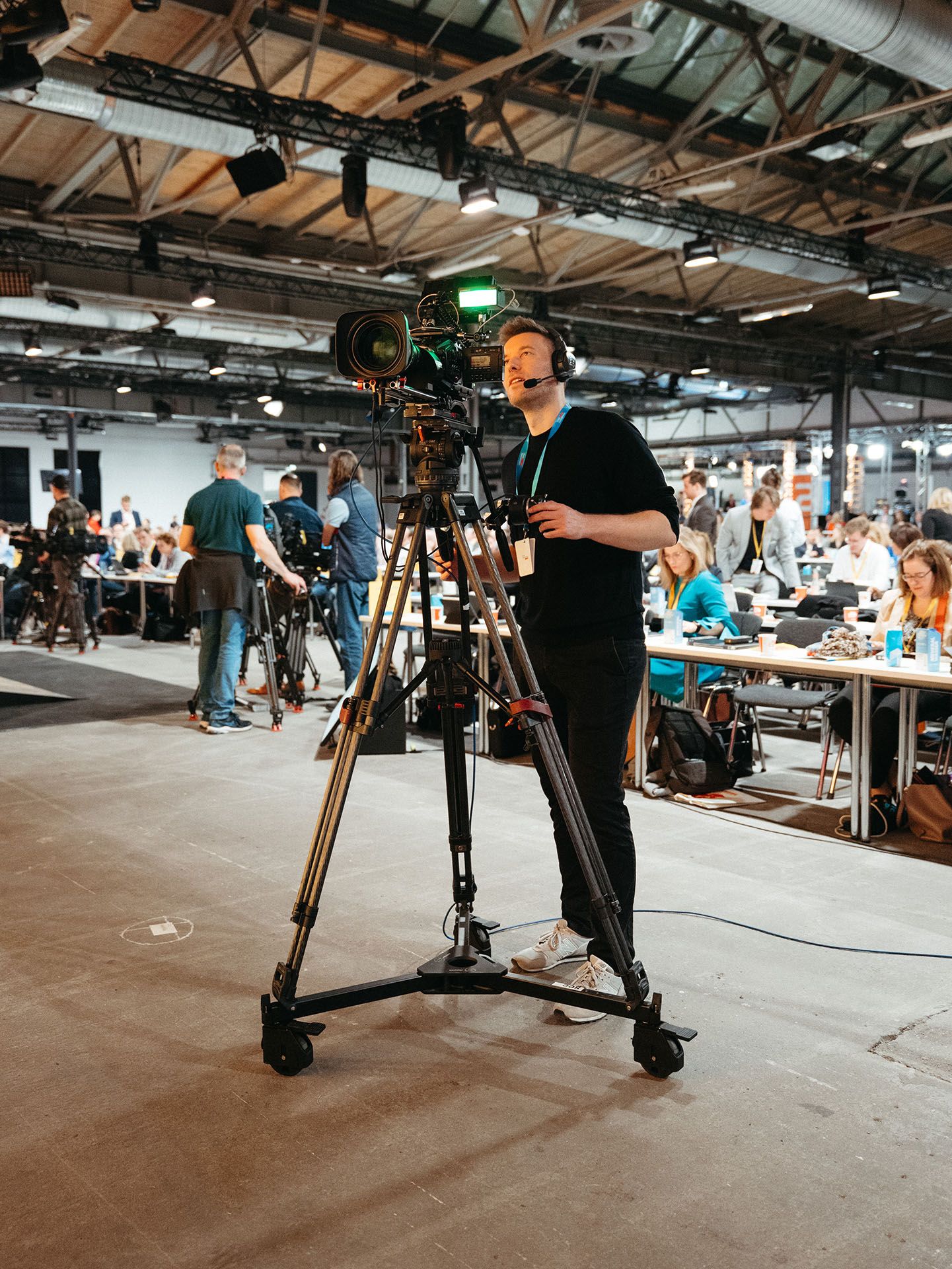 A close-up on a skilled Visionary Berlin camera operator using a professional broadcast lens, showcasing our commitment to top-tier equipment for political events.