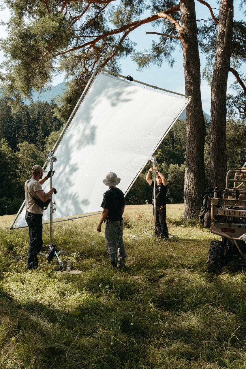 The Visionary Berlin crew sets up a large light diffusion frame in a remote outdoor location to ensure cinematic lighting quality for the Saab Sirius Compact L20C launch film.